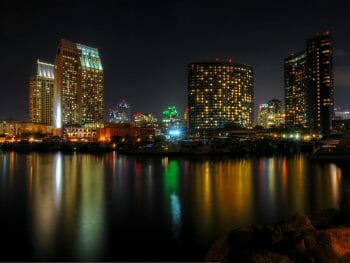 The night lights of the San Diego skyline twinkle and reflects against the water
