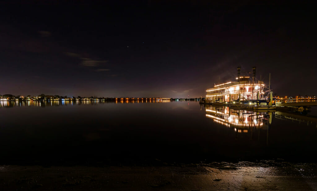 Night view of an authentic, vintage, American riverboat with two chimneys resembling the steamboats used in the 1800s in Mississippi river. A view of Mission Bay and pier in San Diego, southern California, USA.