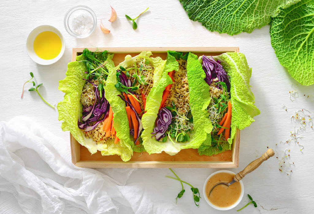 Vegan detox spring rolls with quinoa, sprouts and Thai peanut sauce, view from above, flat lay