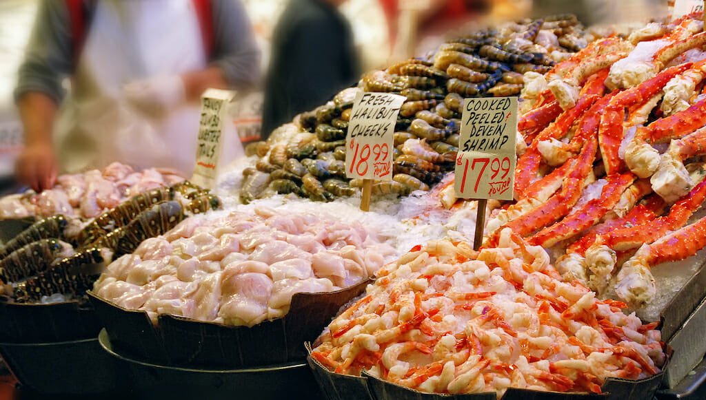 Buckets of a variety of seafood on ice for sale