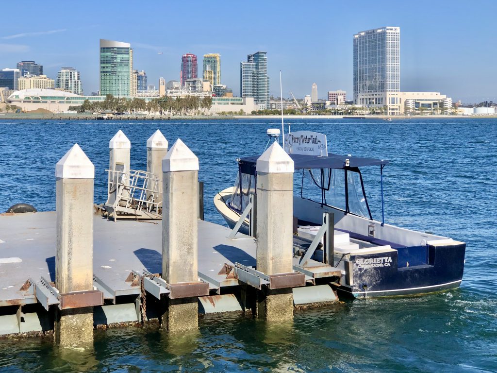 Cornado Ferry Landing Water Taxi with San Diego Skyline in the back on a sunny day with blue skies