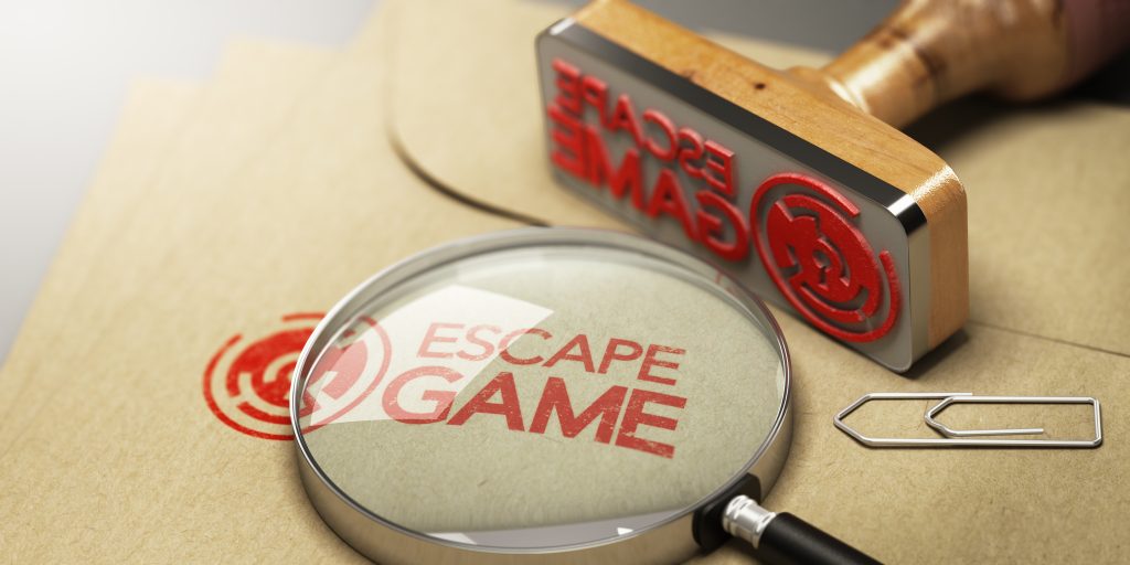 stamp with red inc reading:"Escape Game" and spy glass on manila envelope - Escape Room San Diego Valentines Day