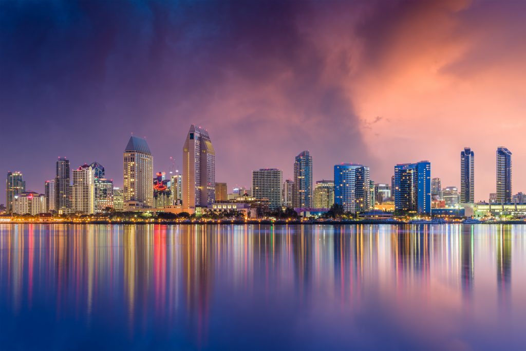 San Diego Skyline reflecting in the water at sunset with purple and pink sky