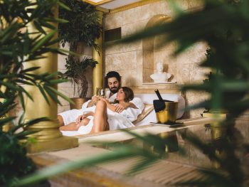 Beautiful young couple enjoying and relaxing in SPA center and drinking wine
