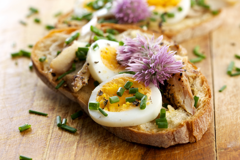 Sandwich with egg, mackerel and edible flowers of chives