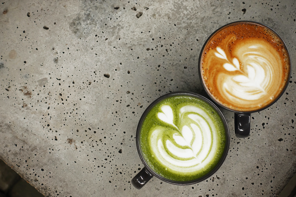 A cup of green tea matcha latte and cup of latte art coffee for background