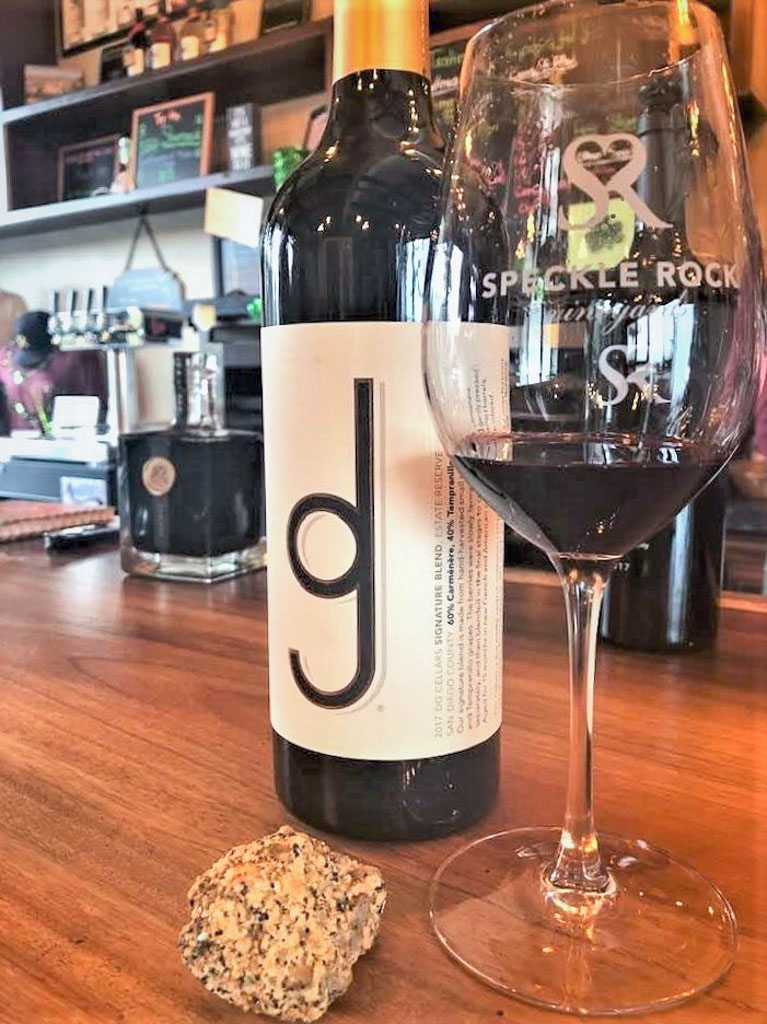 Bottle of wine with a glass on the counter at Speckle Rock Vineyards, one of the top San Diego Wineries