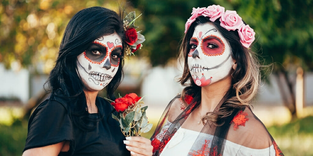 Two young women with sugar skull makeup - a typical Day of the Dead Traditions