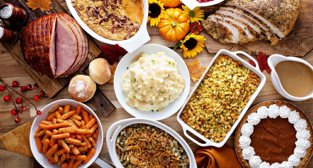 Flatlay photo of a holiday table with ham, and side dishes