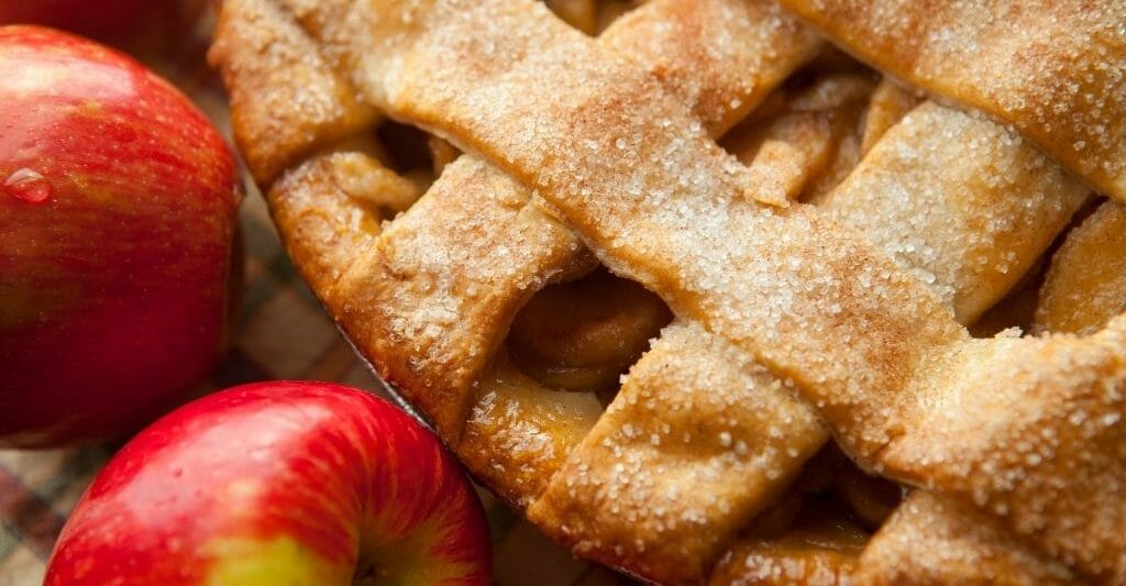 Lattice crust apple pie with whole apples in the bottom corner - Best Apple Pie Bakeries Julian