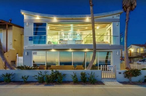 modern white vacation rental beach house with almost all glass front and windows