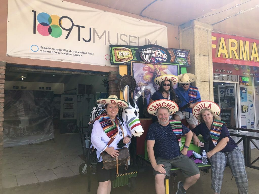 Group of people posing with a fake Tijuana donkey wearing sombreros 