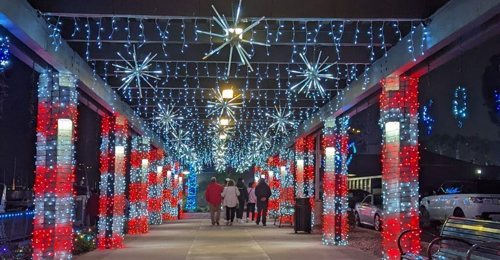 Covered walkway decorated with red and white lights and stars for the Holidays