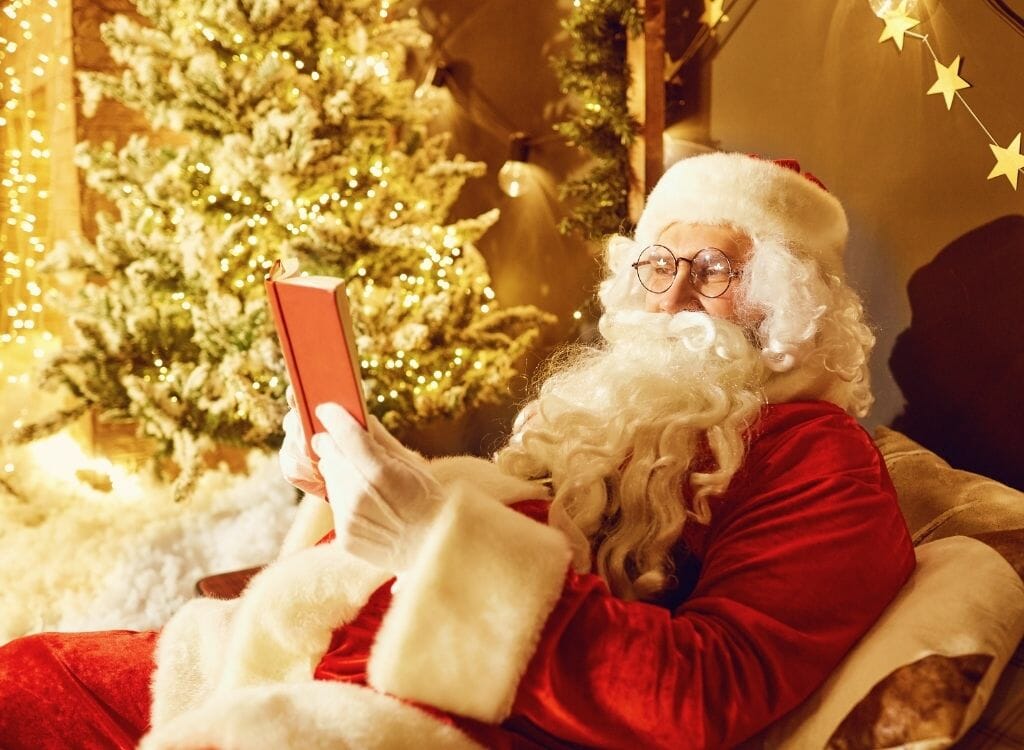 Santa Reading Stories in front of Christmas tree