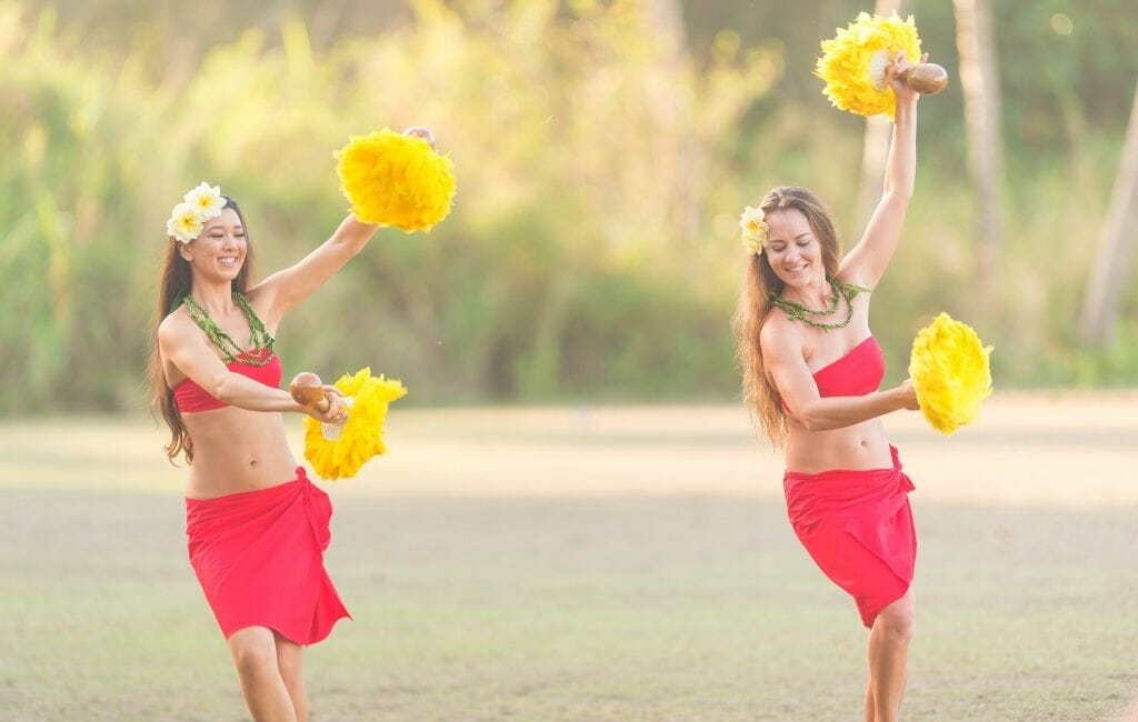 Two ladies performing a Hula dance on the beach