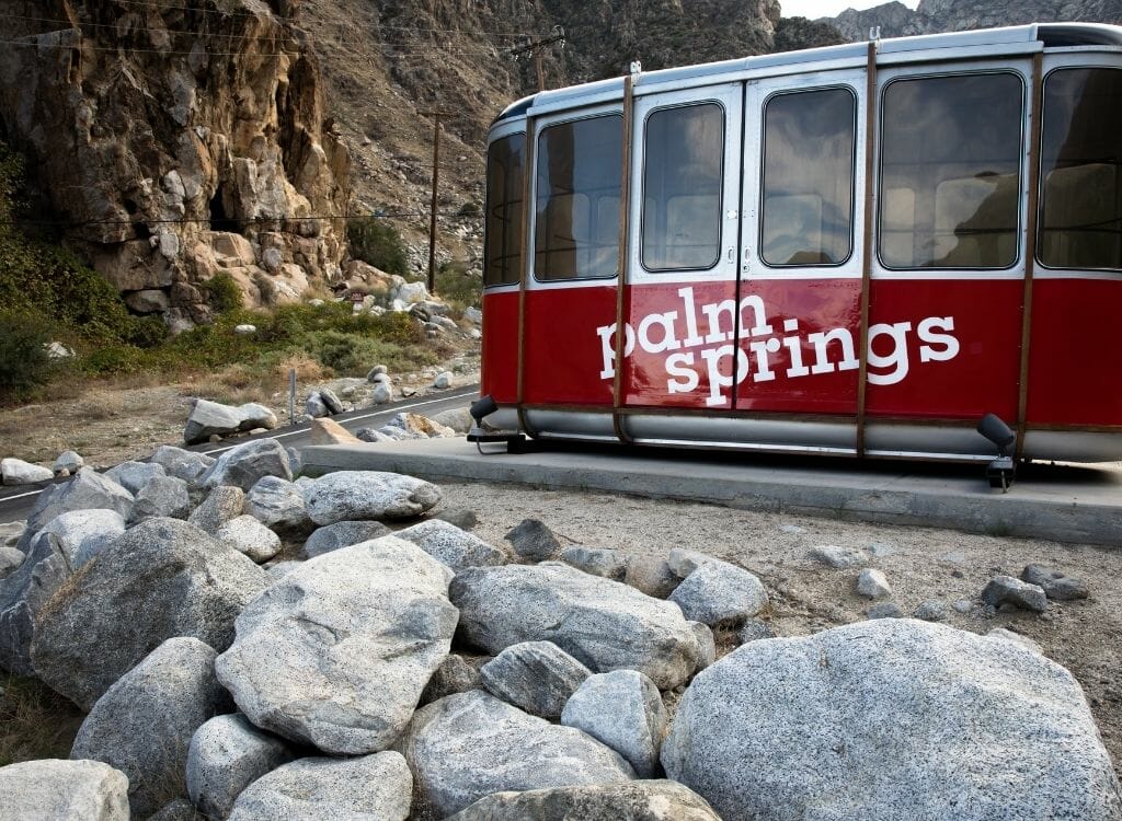 red tram gondola with boulders in the foreground