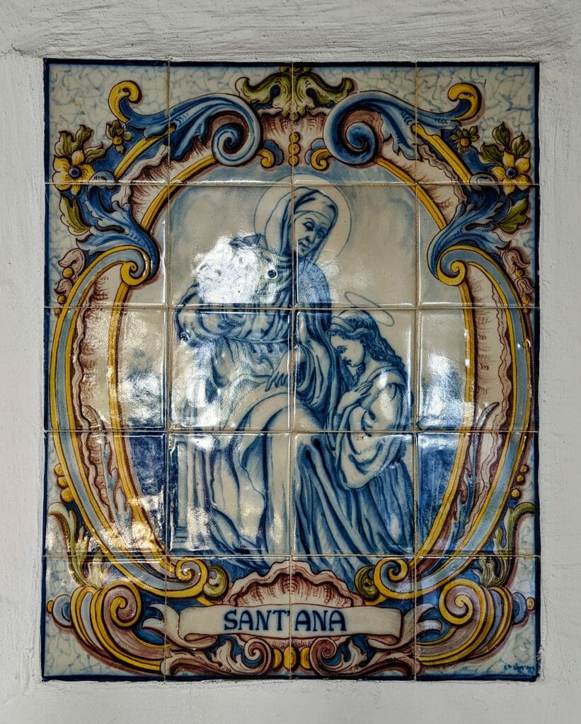 Tile Mural depicting Santa Ana in blue glaze on white tile with a painted frame in gold and blue at San Diego Mission