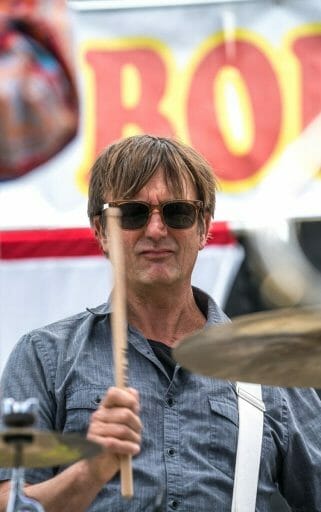 headshot of man with sunglasses playing drums