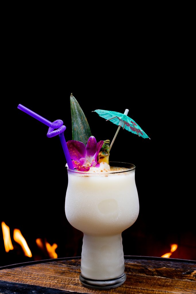cocktail with umbrella and decor at The Grass Skirt Speakeasy