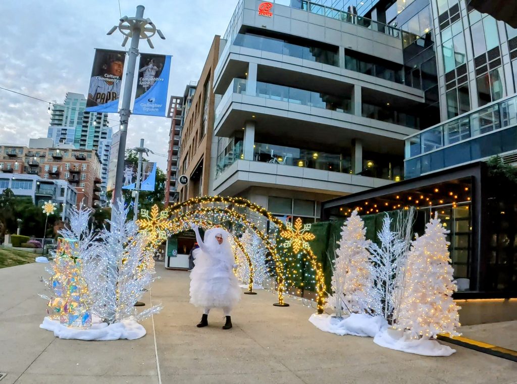 Holiday decor and person dressed in snow flake costume at Petco Park Holiday Market