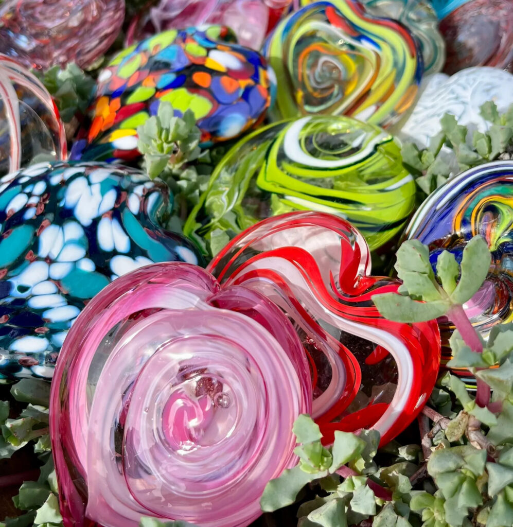 Colorful handblown glass hearts set on a succulent plant