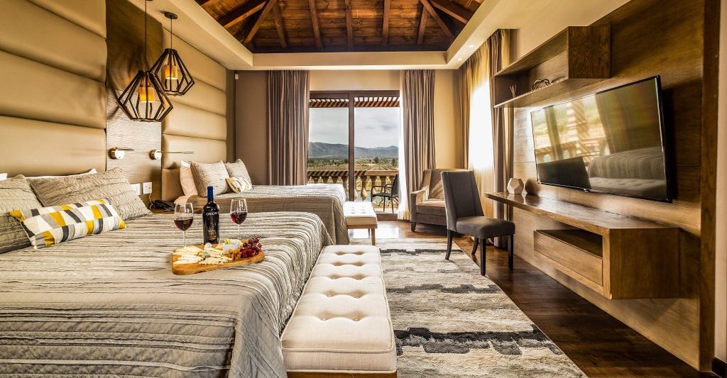 Luxurious hotel room with natual color scheme, wood and light grey/beige fabrics at El Cielo resort - best Valle de Guadalupe Hotels