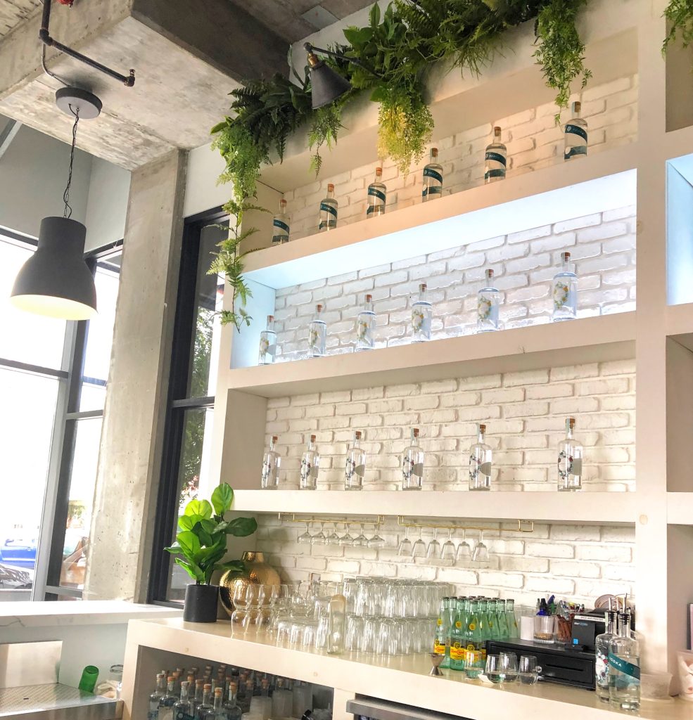 Bar at San Diego's You and Yours Distillery with glassware and bottles