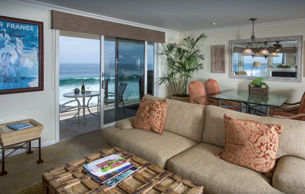 Cozy condo living room and dining room open to balcony overlooking Pacific Ocean.