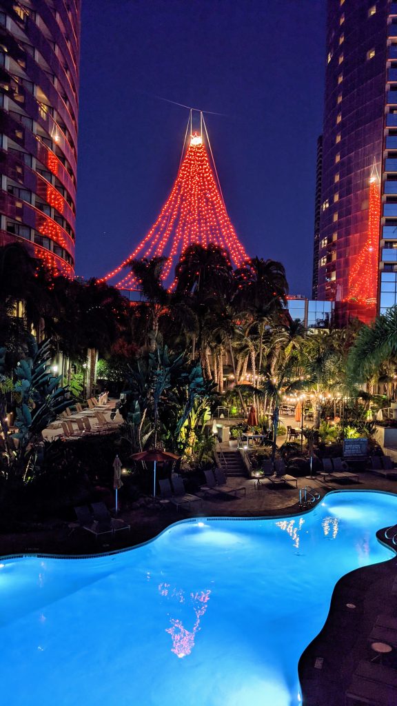 River style Hotel pool at Marriott Marquis Marina in San Diego at night with palm trees and red Holiday light decor
