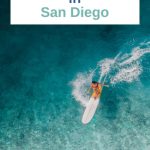 Aerial Shot of surfer in the ocean with white text box: Learn How to Surf in San Diego