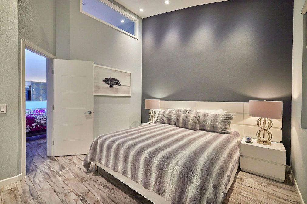 Master bedroom with king size bed, tall ceilings and simple, modern decor. San Diego Vacation Rentals.