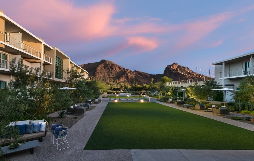 Central lawn with Mountain Shadows hotel on both sides and Camelback mountain in the center during sunset
