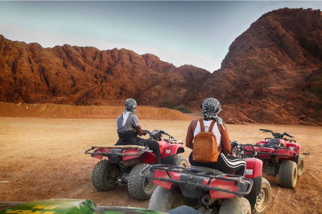 two riders on atvs in the desert