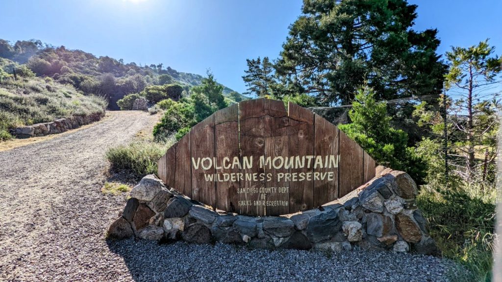 Entrance sign to Volcan Mountain Preserve with uphill trail in the background