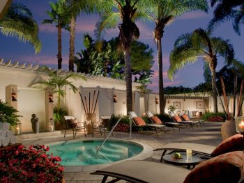 Nighttime shot of hot tub and pool area with lounge chairs and palm trees. Loews Coronado Bay Resort.