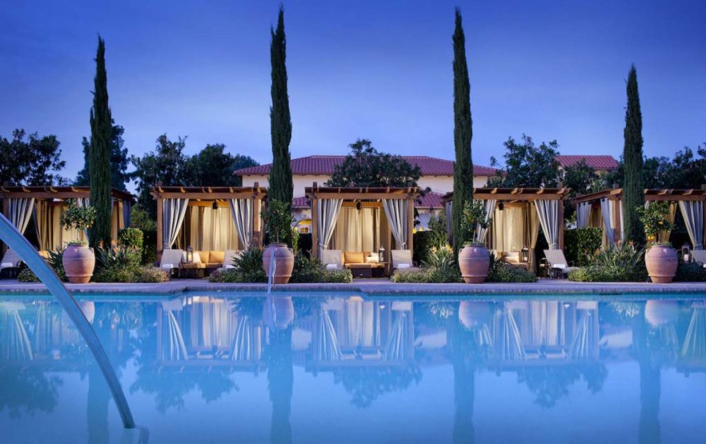 Outdoor pool lined with luxury cabanas and planters at night. Rancho Bernardo Inn, Luxury Boutique Hotels San Diego.
