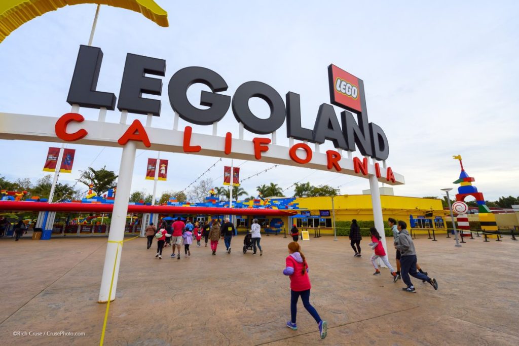 Kids running under the entrance sign of Legoland California Amusement Park
