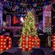 Inside of Santa's Lair Night Club with red lettering "Ho Ho Ho" and Christmas tree and decoration behind it