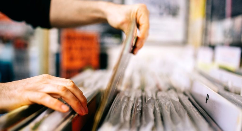Person looking at vinyl records in record store. Record Store in San Diego.