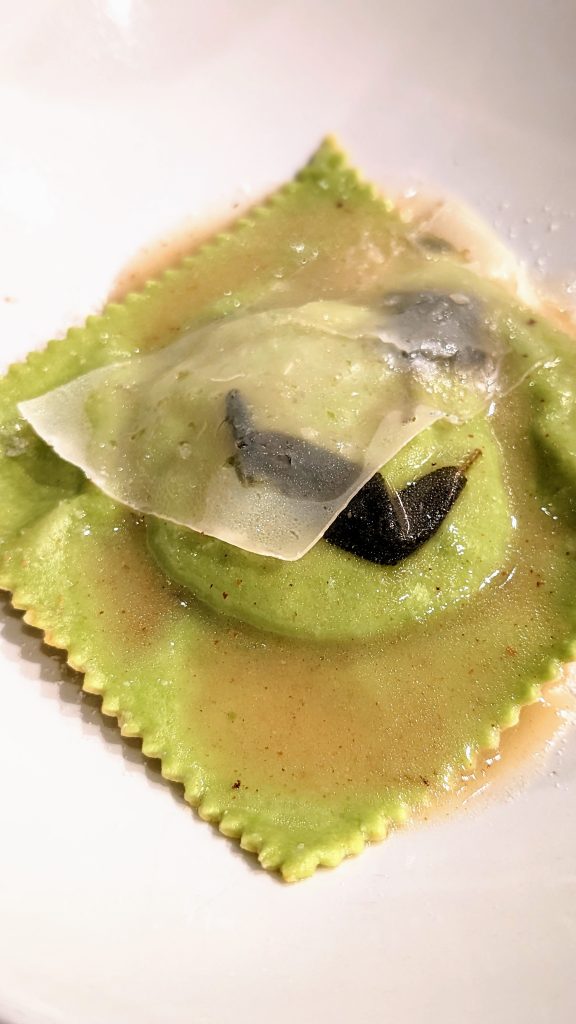 Green ravioli stuffed with whole egg yolk drizzled with sage butter