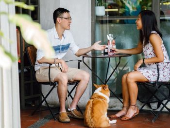 couple and corgi dog sitting at a Dog friendly restaurants San Diego