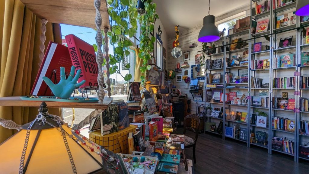 inside of Libelula Bookshop in Barrio Logan with display tables and shelves full of books
