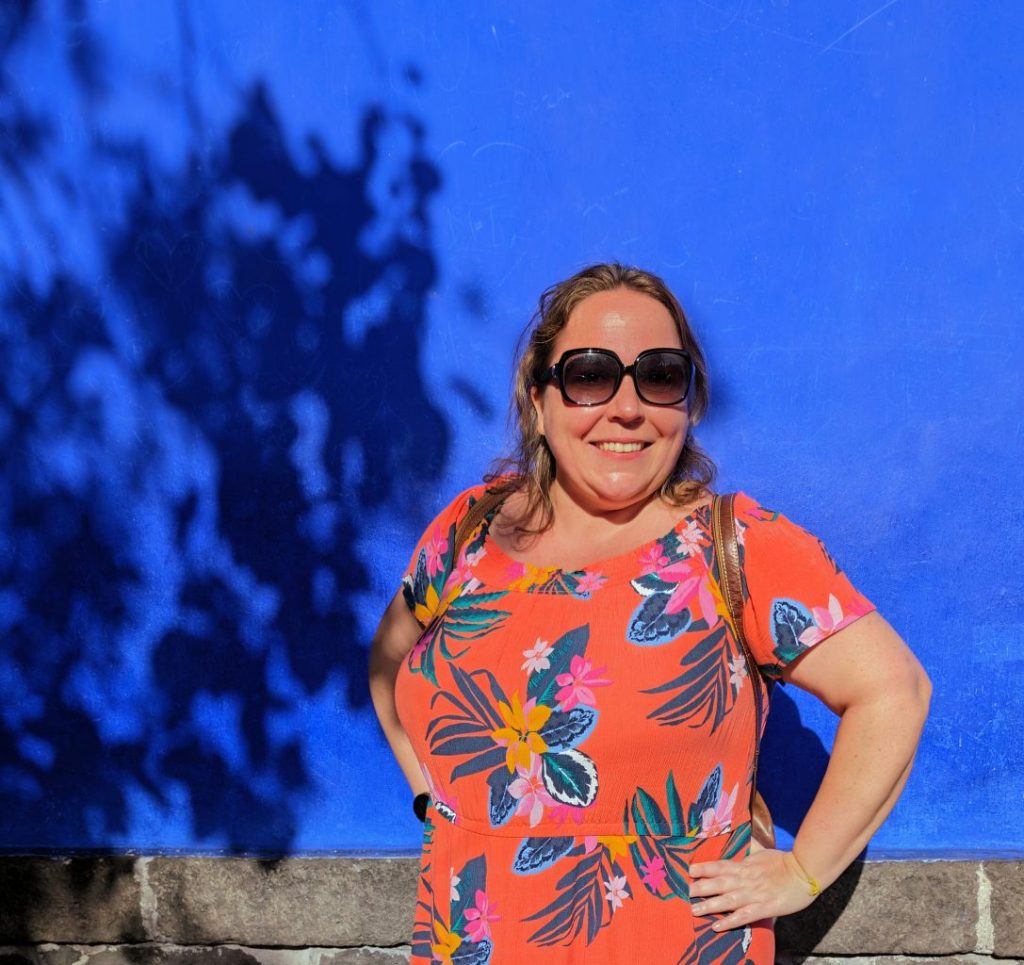 Maria Haase in front of blue wall at Casa Azul Mexico City